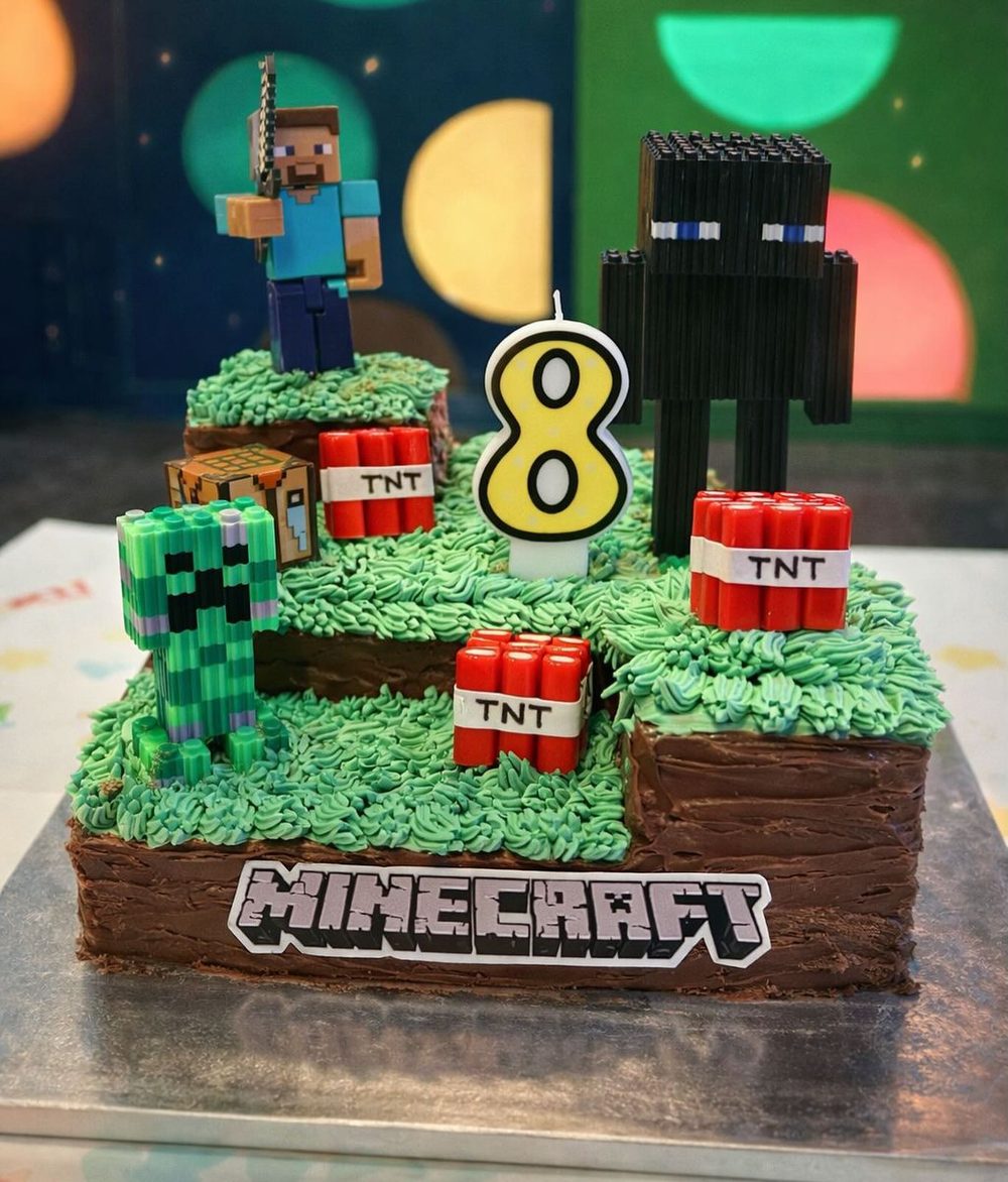 Torta temática de Minecraft con figuras del juego y una vela con el número 8